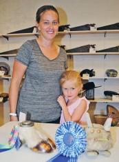Jennifer Ledley (left) stands with an entry from her father, Roger Stedman, which was an ink well made from a goat's hoof at the antique show of the 2018 Hardin County Fair. With her is her daughter, Elizabeth, who won the top prize in the 5-6-year-old division of the Funny Bunny contest. 