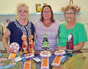 Diana Roll of Kenton, (left), earned a reserve championship with her decorative painted fabric creation and her Native American figurines captured a grand championship honor. Deanne Doornbos (center) of Kenton earned a reserve title with her Christmas tree. Sue Dickinson's decorative painting entry captured top honors in the fine arts show.