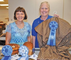 Elaine Hoover of Kenton (left) won a pair of honors in the baked goods competition of the arts and craft show. Her whole wheat bread loaf was named reserve champion and a grand championship was awarded to Hoover's coffee cake. Annetta Holmes of Kenton earned a grand championship title with her sewing recreation of a 1930s-style Mill Girl dress. 